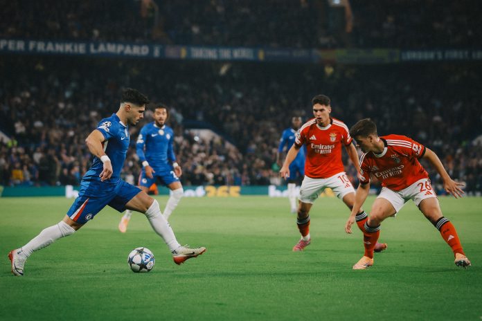 Pedro Neto berusaha melewati dua pemain Benfica pada laga Liga Champions 2025/2026 di Stamford Bridge, Rabu (1/10/2025). Chelsea menang 1-0 lewat gol bunuh diri Richard Rios pada menit ke-18 setelah gagal mengantisipasi umpan Alejandro Garnacho.