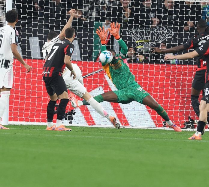 Momen kiper AC Milan, Mike Maignan, menepis tembakan pemain Juventus. Laga berakhir imbang pada pekan ke-6 Serie A di Stadion Allianz, Turin, Senin (6/10/2025).