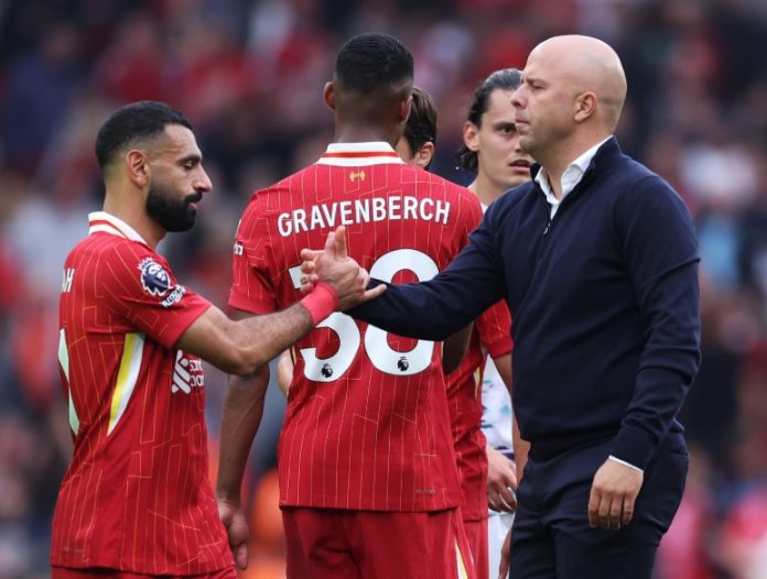 Momen pemain Liverpool Mohamed Salah berjabat tangan dengan pelatih Arne Slot dalam sebuah pertandingan.