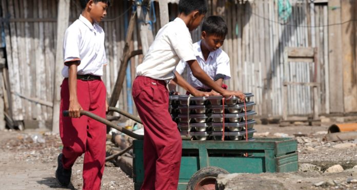 Siswa SDN 1 Pulau Maringkik Kab. Lombok Timur membantu membawa Ompreng Makanan Bergizi Gratis. Sebanyak 638 siswa setiap harinya menerima manfaat program MBG ini. Rabu (26/11/2025).